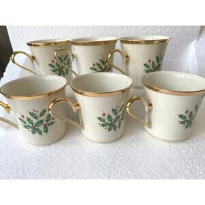 Lenox Holiday mugs, holly and berry motif and 24-karat gold trim accents.